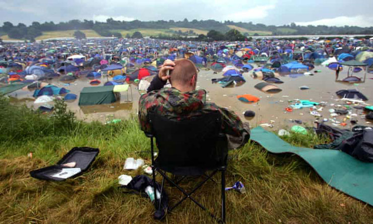 A person sitting in a chair at a beach with a computer

Description automatically generated with low confidence